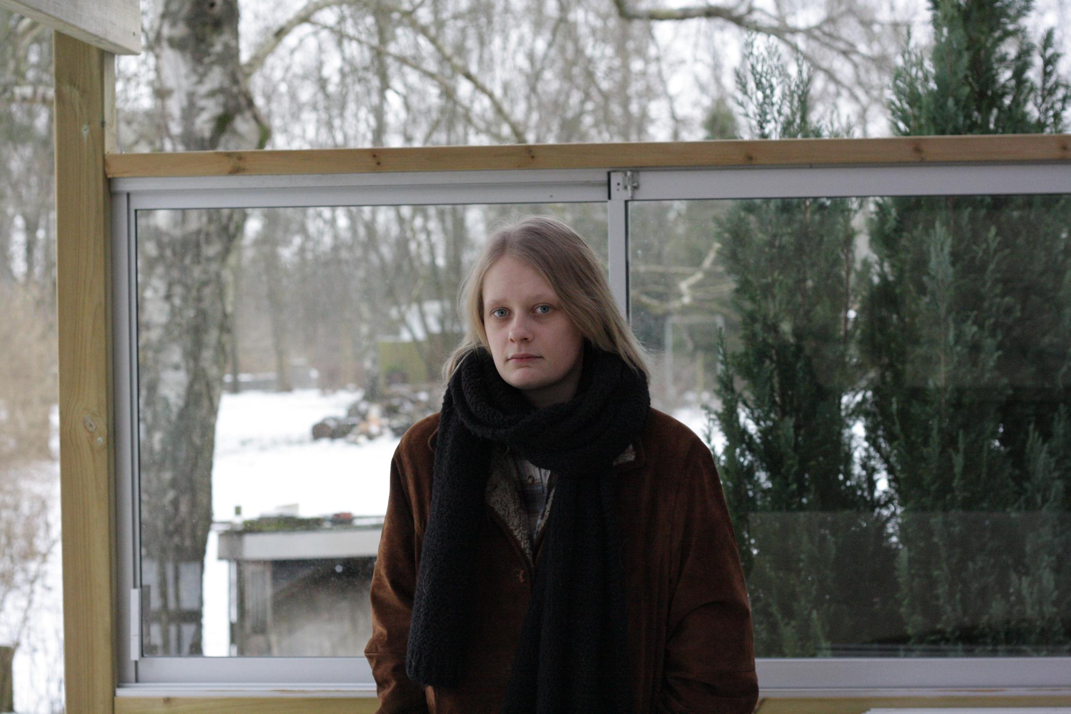 Ebba Ozolins, framför ett fönster med snö utanför och ytterkläder på.